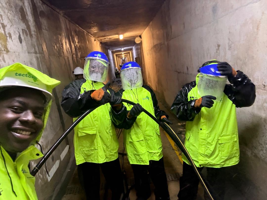 Crew in respirators applying protective industrial coatings