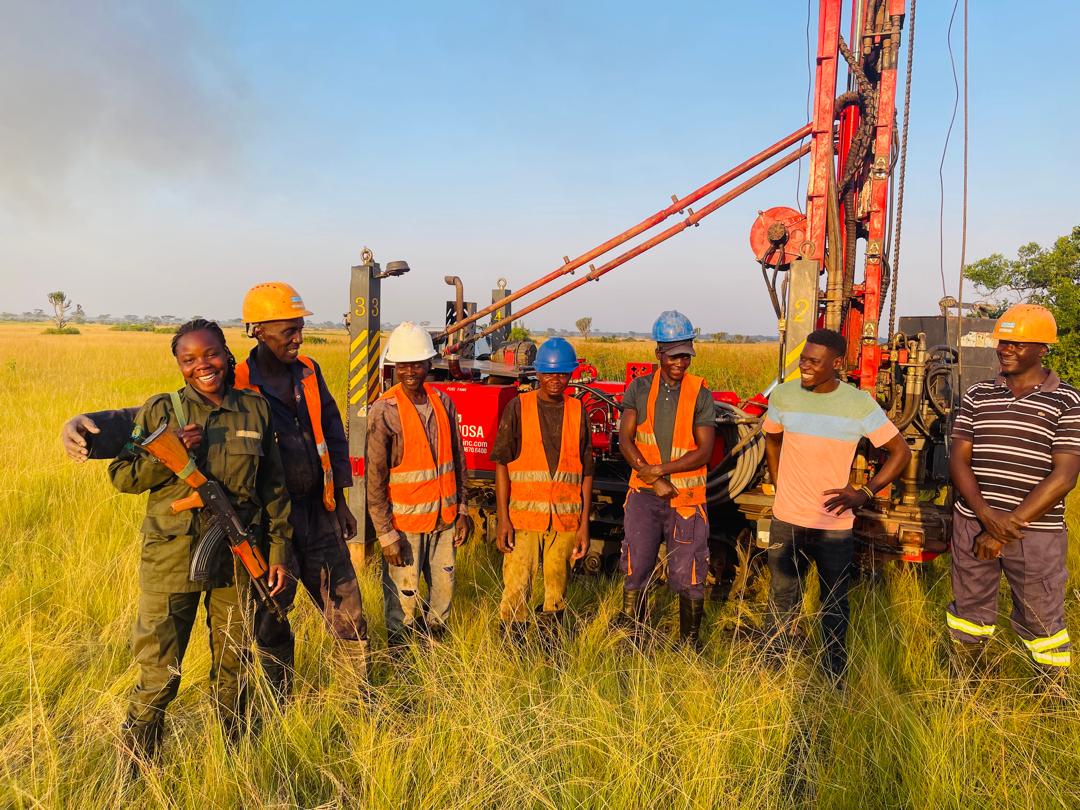 Tectoni field team posing at a drill rig in warm evening light